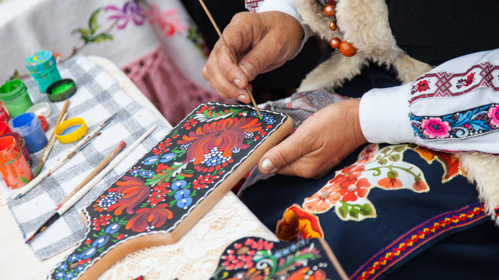 Kobieta malująca słowiańskie wzory na desce